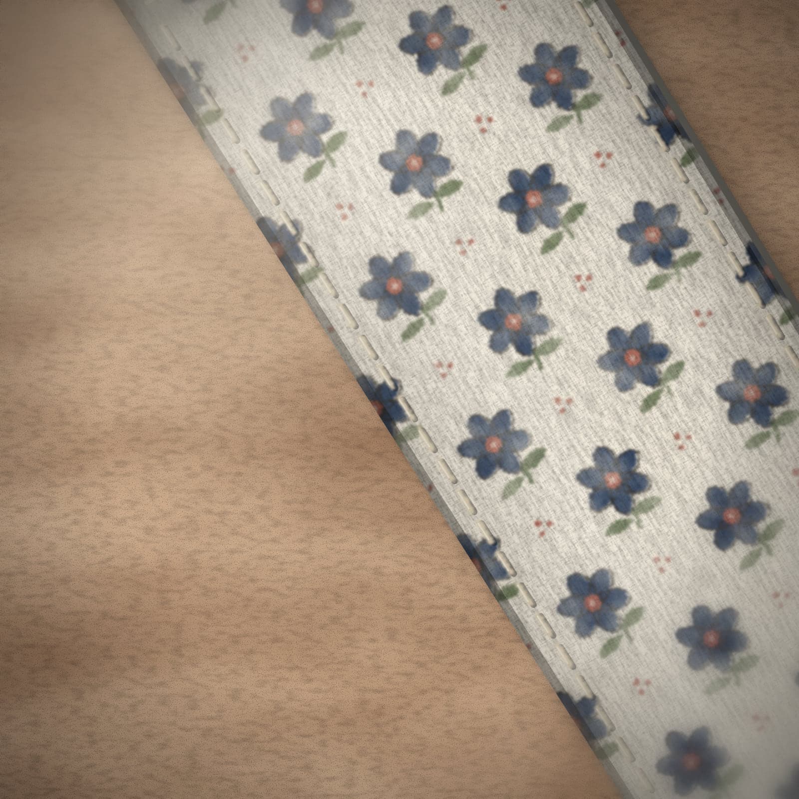 Close-up of stitched edges and holes on an ivory floral strap.